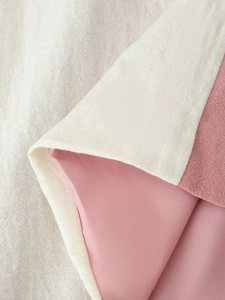 Dettaglio del tessuto grezzo bianco crema con fodera interna rosa liscia e cuciture