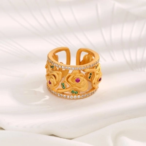 Detailed macro of vintage gold flower ring with red and green gemstones and pavé stones