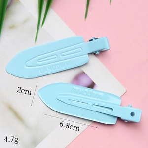 Light blue seamless duckbill hair clips set in a glossy finish with metal lettering