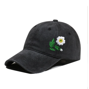 Close-up of vintage washed black cotton baseball cap with daisy flower embroidery