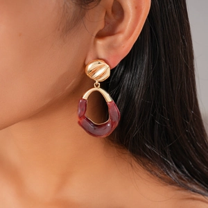 Close-up of a model wearing retro resin hoop earrings in dark brown and gold finish