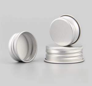 Close-up of aluminum screw caps with silver frosted finish and anti-slip vertical texture