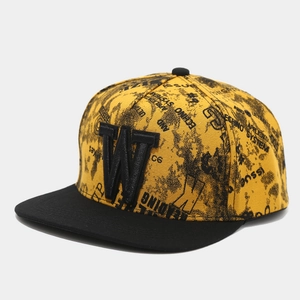 Detail of 3D embroidered letter W and graffiti patterns on a yellow hip-hop flat brim cap