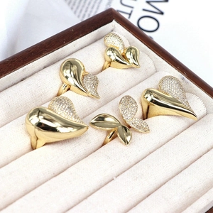 Adjustable 18k gold rings with zircon butterfly and heart designs on beige velvet
