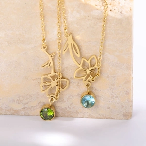 Macro shot of two vintage floral pendants with green and sky blue zircon stones on gold chains