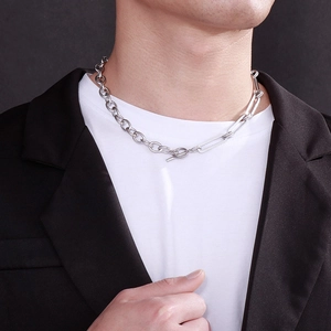 Close-up of OT clasp chunky stainless steel necklace worn by a model in a black blazer