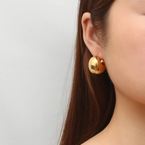 Minimalist golden hollow round stainless steel hoop earrings worn on female ear
