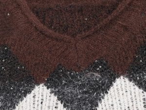 Makro-Detail des V-Ausschnitt-Strickpullovers mit Paillettenbesatz und flauschiger Textur