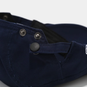 Close-up of adjustable metal buckles and navy cotton twill on the back of the beret cap