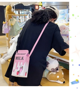 Creative strawberry milk carton crossbody bag shown on a model in a boutique store