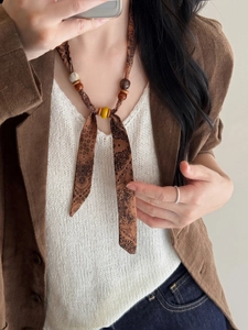 Close-up of ethnic style paisley chiffon necklace with wooden beads on a model