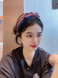 Gros plan d'un serre-tête en tricot bordeaux avec nœud sur un modèle de style ethnique