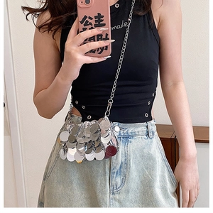 Close-up of a silver sequin crossbody mini bag with reflective metallic disks and chain strap