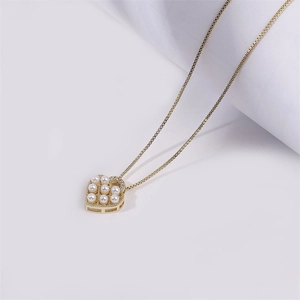 Classic gold-plated heart pendant necklace with pearls and zircon on white background