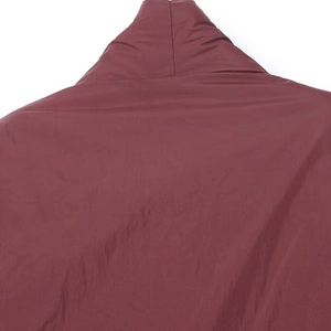 Detalle de las costuras y textura de la tela en el cuello de una chaqueta kimono roja