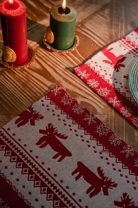 Close-up of red and white woven Christmas place mat with reindeer and snowflake patterns
