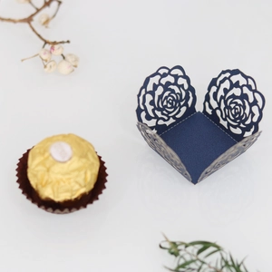 Gros plan de la boîte à bonbons bleu foncé ajourée au laser avec décor de roses