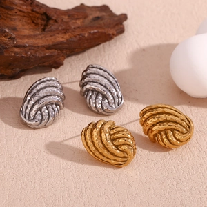 Detail of woven knot earrings with hammered texture in gold and silver finish