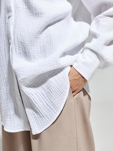 Close-up of white cotton crepe shirt fabric texture with natural fibers and buttons