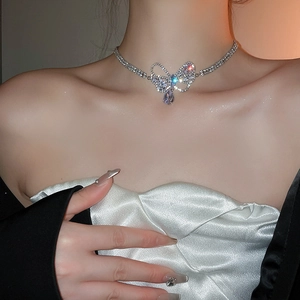 Close-up of a silver bow necklace with zircon water drop pendant on a woman's neck