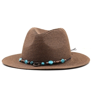 Detailed view of the woven straw fedora hat featuring bohemian turquoise beads and wood trim