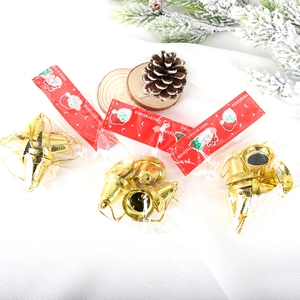 Set of 3cm golden Christmas bell ornaments with pine cones on white fabric background