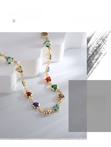 Close-up of golden chain necklace featuring multi-color heart-cut zircon gemstones