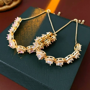 Detail of adjustable gold bolo bracelet with pink and clear heart-cut cubic zirconia