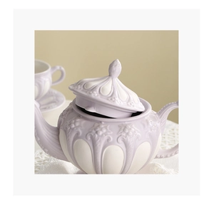 Detail of lavender ceramic teapot with white floral relief in vintage British style