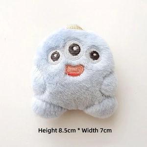 Macro shot of 8.5cm light blue plush monster detail with three-eye embroidery