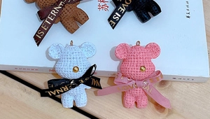 Close-up of four resin bears with crochet texture and Love Is Eternal gold ribbon detail