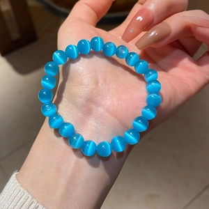 Close-up of blue cat eye stone beaded bracelet showing translucent luster on wrist