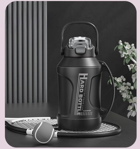 Detail of matte black sporty water bottle with portable handle on a tennis racket