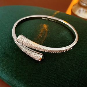 Detail of silver bypass bangle with pavé-set zircons on green velvet display