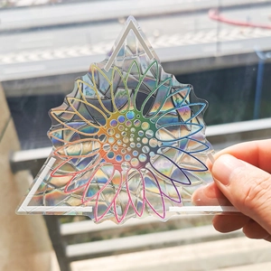 Rainbow prism sunflower suncatcher decal creating colorful light on a glass surface