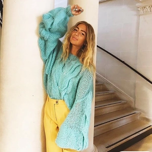 Detail of teal chunky cable knit sweater featuring hollow out texture and relaxed fit