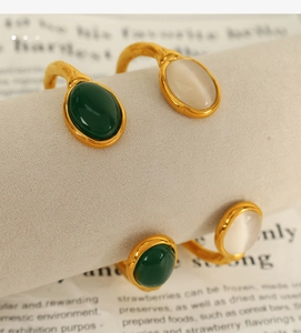 Detailed macro view of gold-plated oval cat eye stone inlay on adjustable bangle