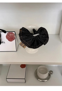 Detail of dark blue denim scrunchie with contrast stitching on a ceramic tray