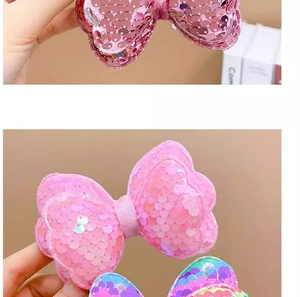 Detail of pink and rainbow sequin bow hair clips for girls showing shiny texture