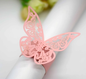 Close-up of laser-cut pink butterfly paper napkin ring with elegant hollowed-out patterns
