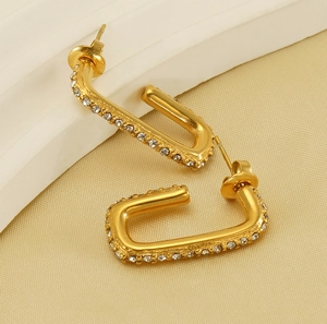 Close-up of gold-plated U-shaped earrings with micro-pave cubic zirconia inlay detail