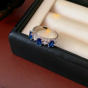 Adjustable silver ring with hollow lace design and three sparkling blue zircons