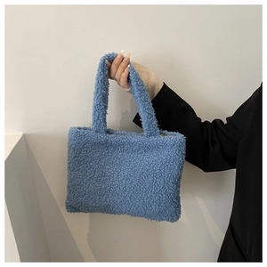 Detail of blue plush teddy fleece handbag with soft texture and minimalist hand-held design