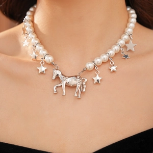 Close-up of star and pony charms on beaded pearl necklace for women
