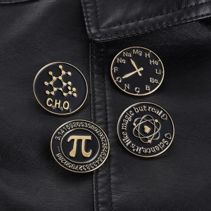 Set of 4 black and gold enamel science pins with math and chemistry motifs on a leather jacket