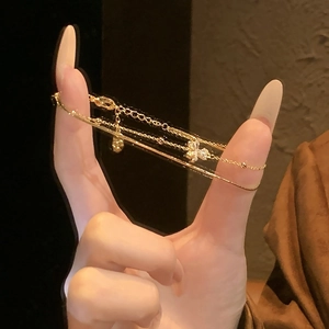 Close-up of 18K gold-plated flower bracelet with sparkling crystals and heart charm