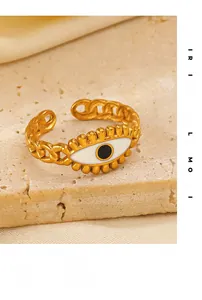 Détail macro d'une bague chaîne dorée avec œil en émail sur un support en pierre