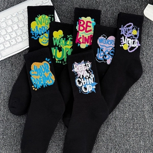 Black crew socks with colorful graffiti letters and motivational quotes on cotton fabric