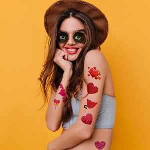 Fashionable red heart tattoo stickers on a woman's neck and arms for Valentine's Day