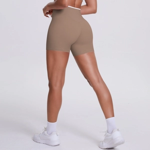 Detail of high waisted yoga shorts showing peach lift effect and camel seamless fabric